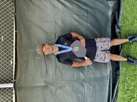 Dr. Lane Odom wearing a tournament medal and holding his paddle in front of a black backdrop
