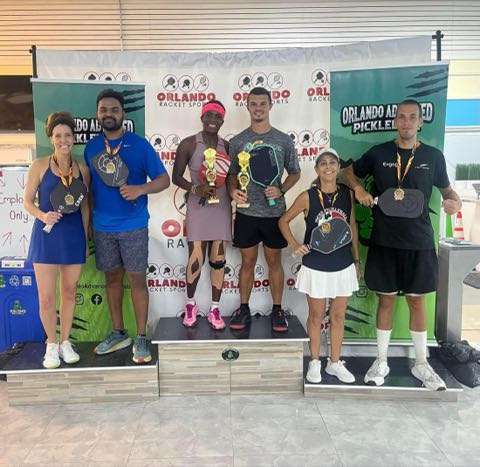 Podium ceremony at Orlando Advanced Pickleball with medalists holding paddles